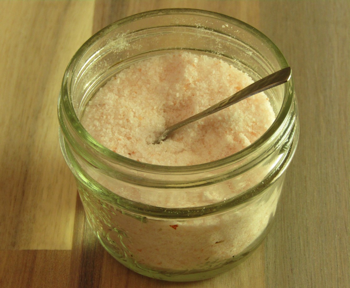 a small mason jar holding a spoon and salt