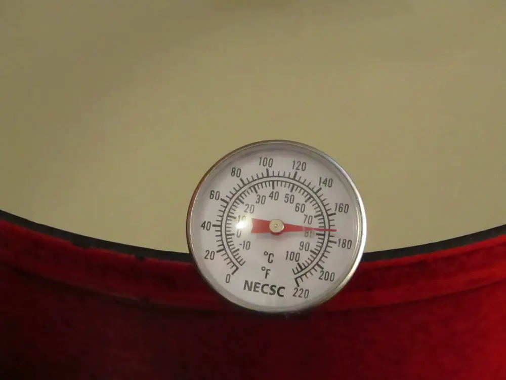 Thermometer in a pot of milk reading 80 degrees celsius