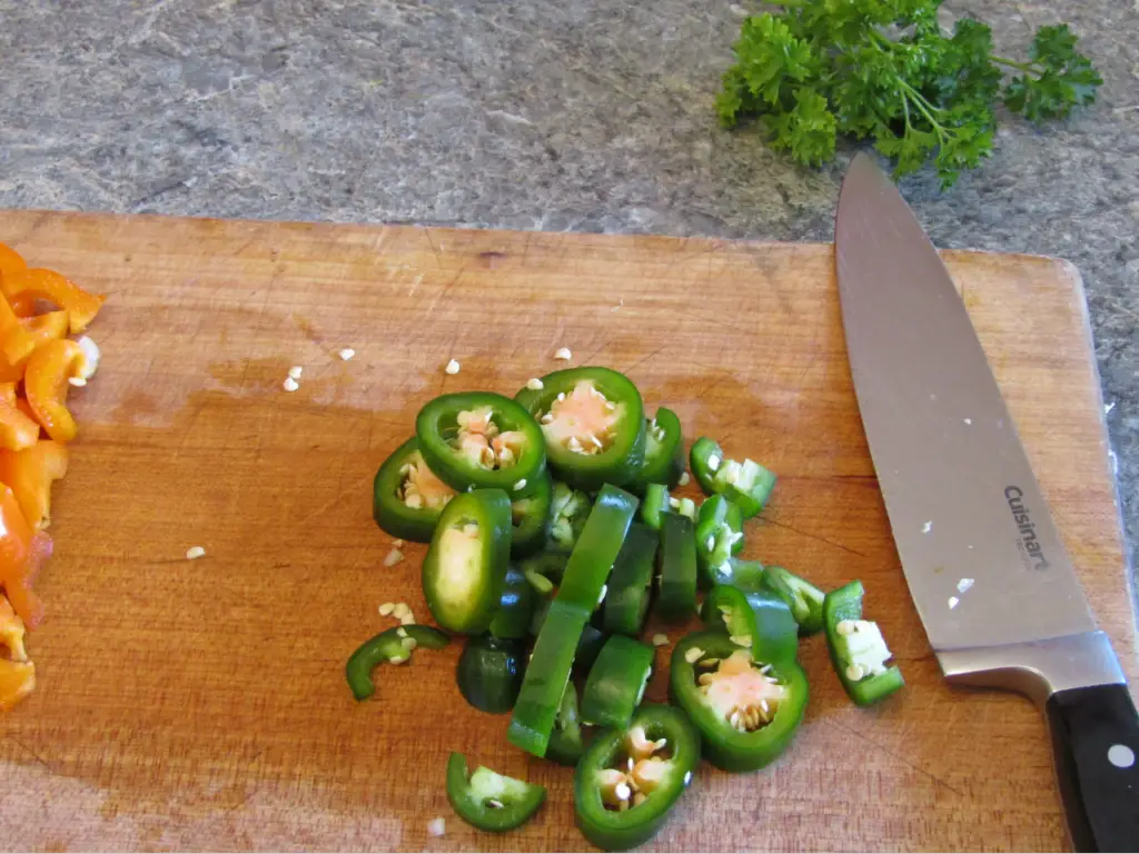 Chopped jalapenos on cutting board with knife