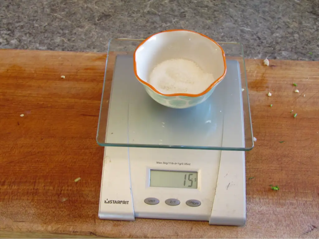 Bowl of salt on a digital scale showing 15 grams