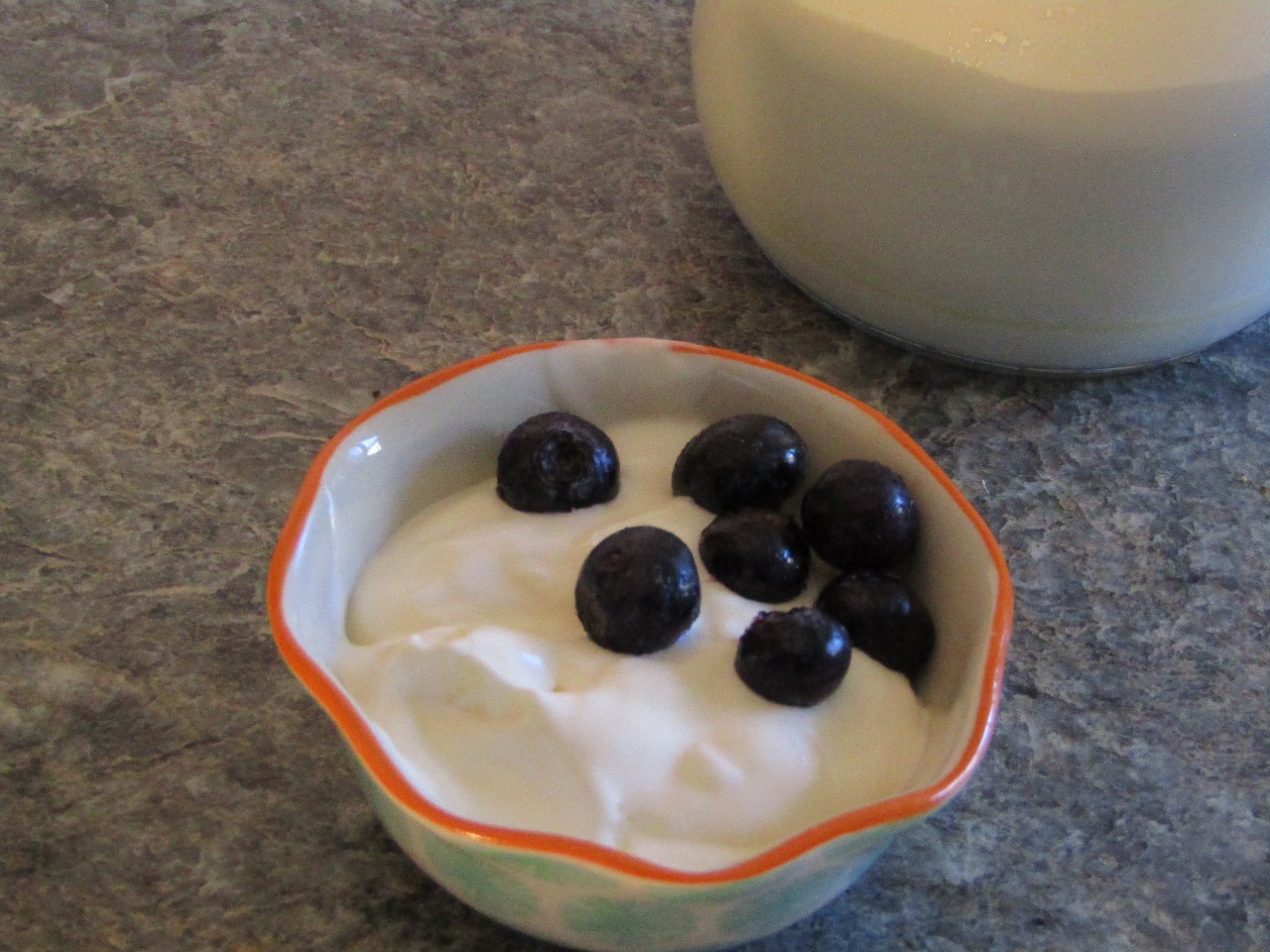 Small bowl of blueberries on heavy cream yogurt