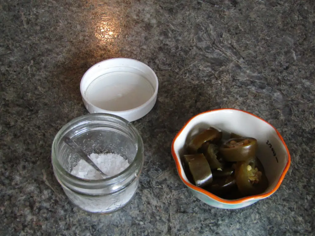 Salt container with a jar of jalaenos in a bowl