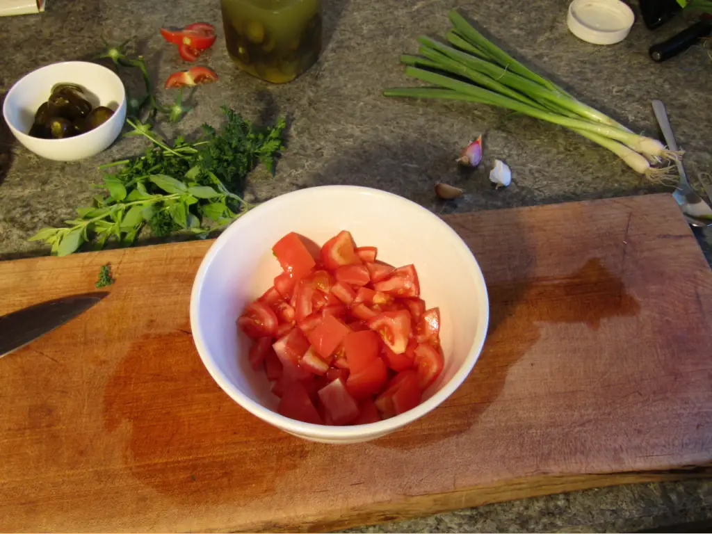 Mixing bowl with three chopped tomatos in it