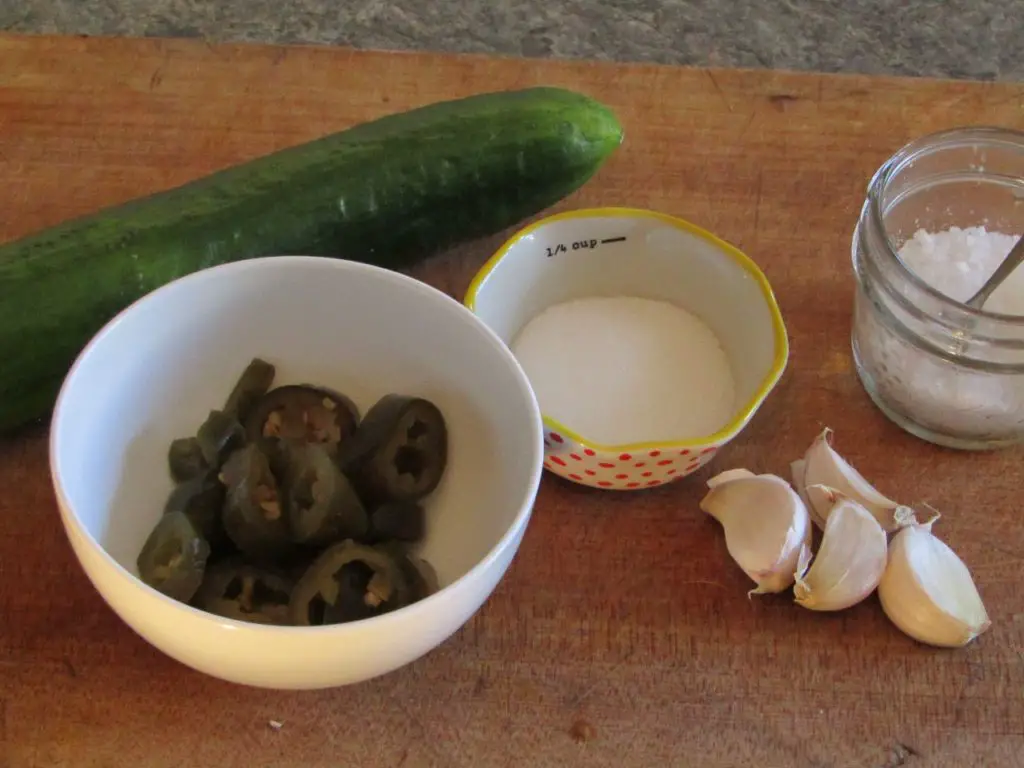 ingredients for fermented hot pepper relish: one cucumber, fermented jalapenos, garlic cloves, sugar and salt