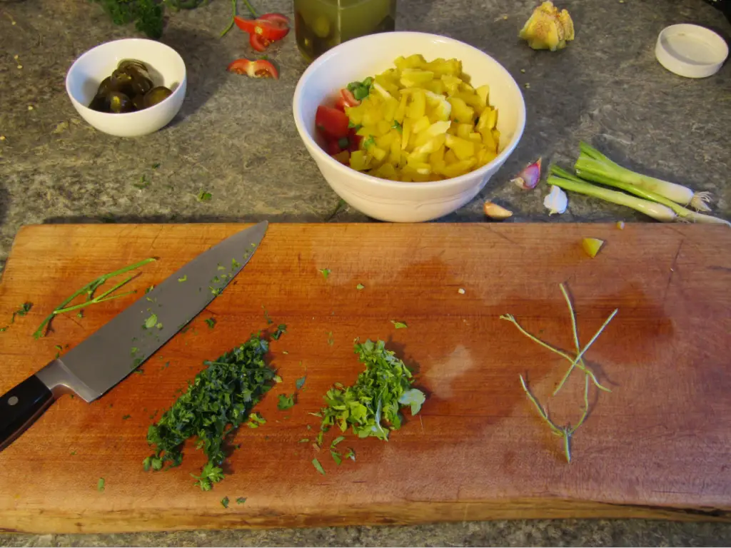 minced parsly and oragano with stalks removed on a cutting board