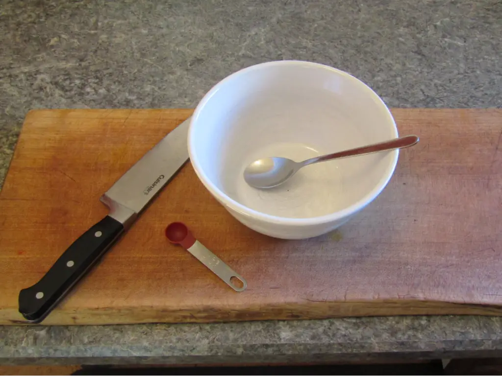 equipment needed to make fresh salsa with fermented hot peppers: a cutting board, kitchen knife, mixing bowl, measuring spoon and mixing spoon