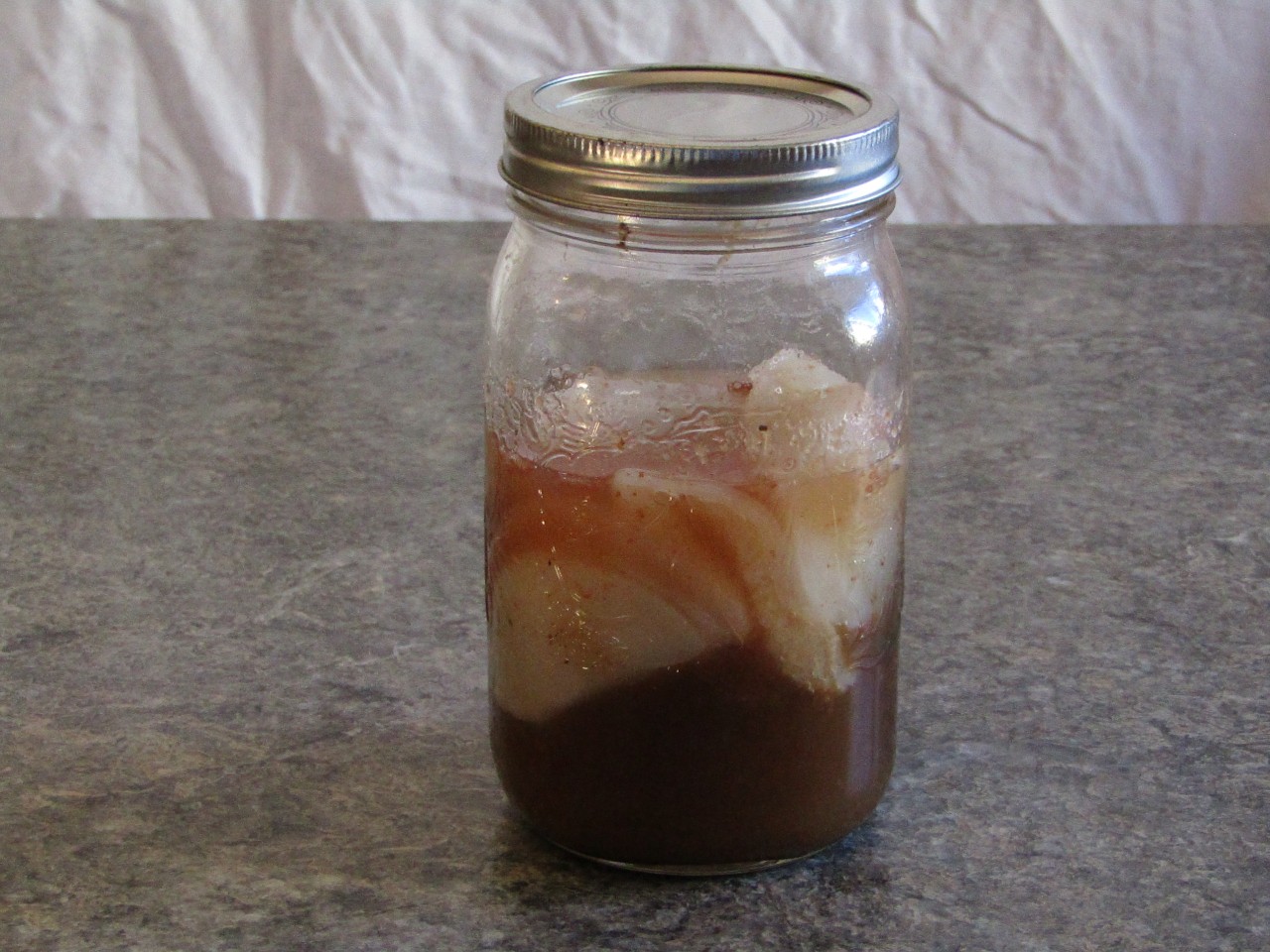 A mason jar filled with kombucha SCOBYs